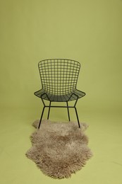 Photo of Stylish chair and rug on olive background. Used stuff