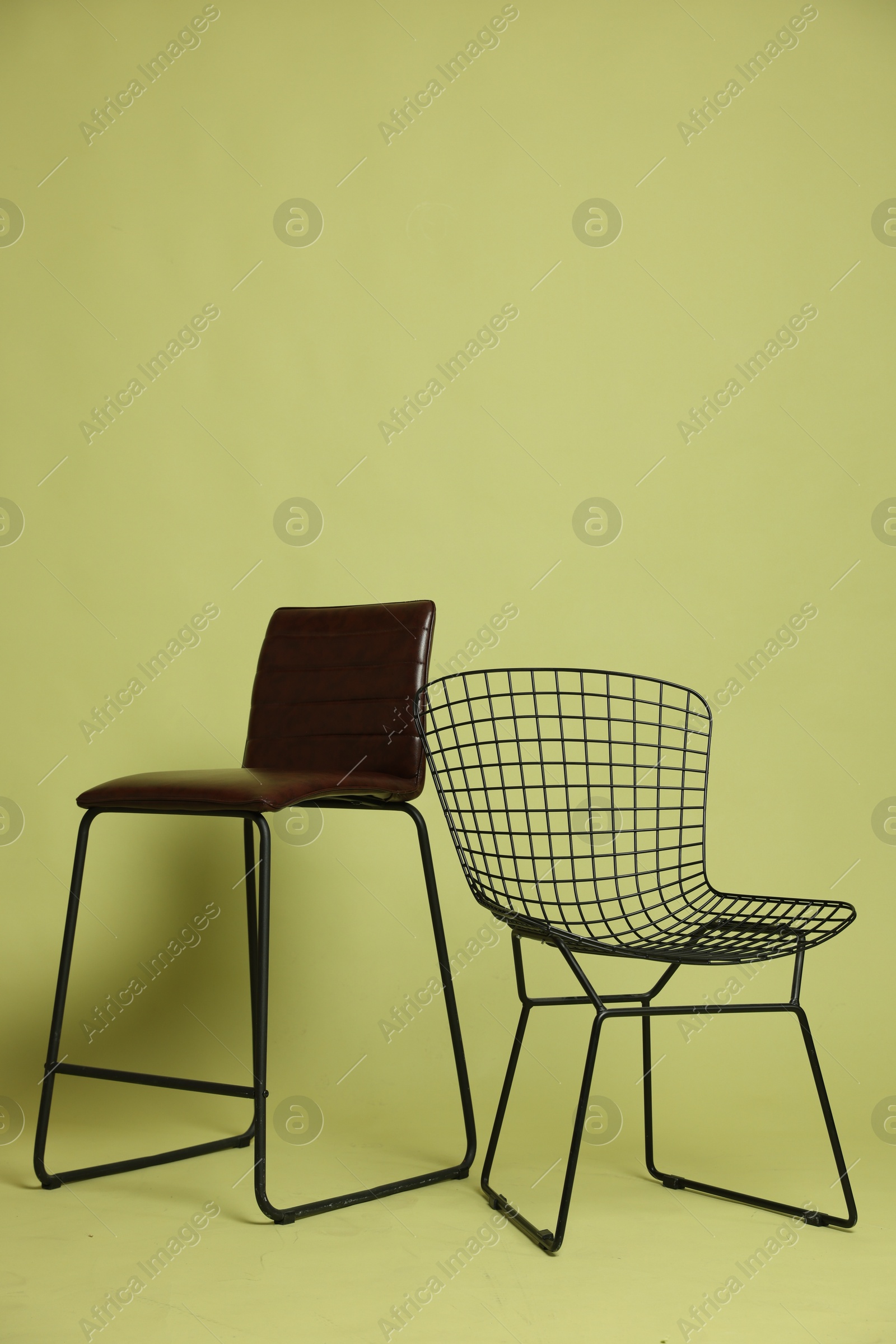 Photo of Bar stool and chair on olive background. Used stuff