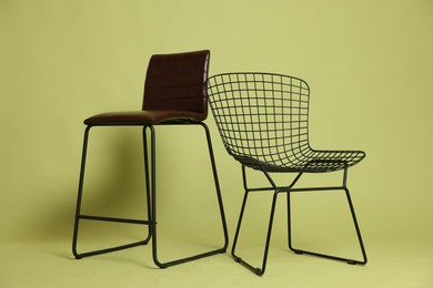 Photo of Bar stool and chair on olive background. Used stuff