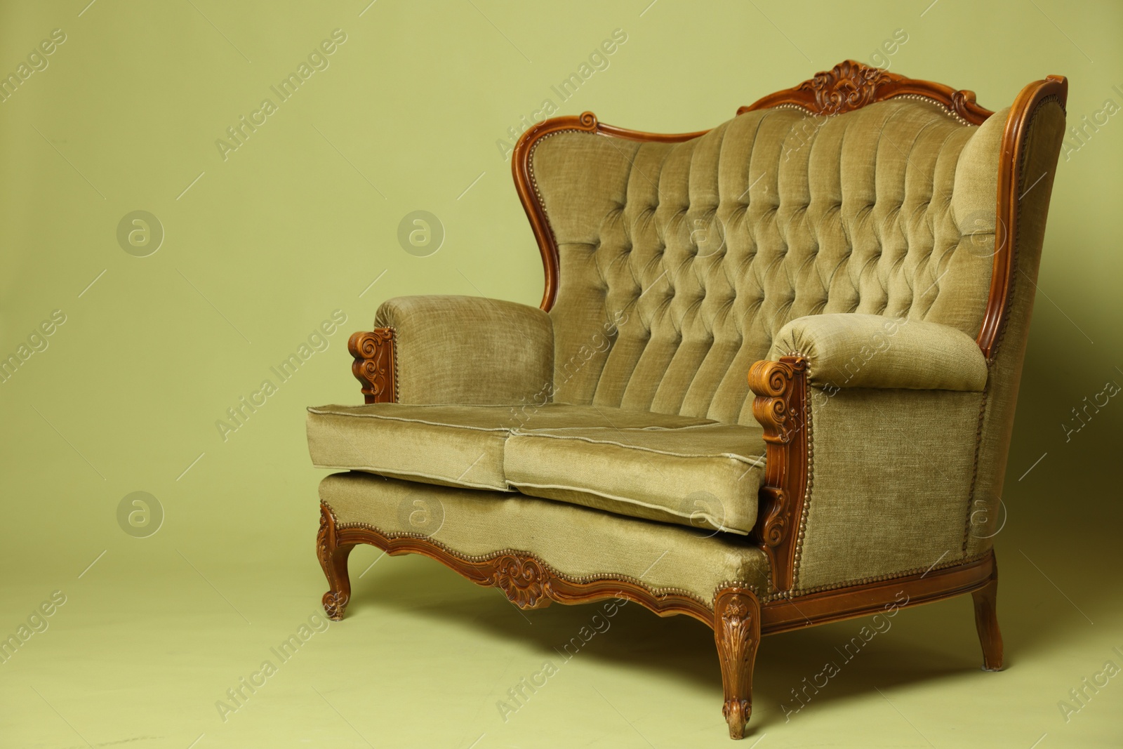 Photo of Soft sofa on olive background, space for text. Used stuff