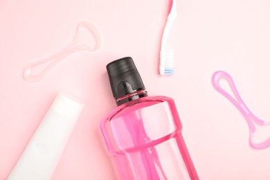 Photo of Mouthwash and other oral hygiene products on pink background, flat lay