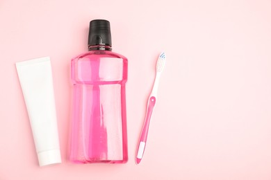 Photo of Mouthwash, toothbrush and toothpaste on pink background, flat lay. Space for text