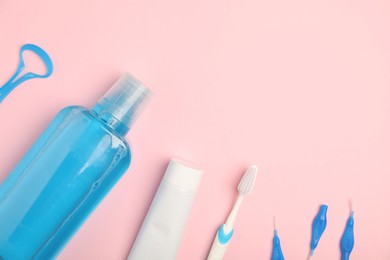 Photo of Mouthwash and other oral hygiene products on pink background, flat lay. Space for text