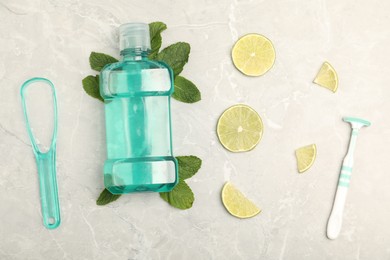 Photo of Mouthwash, other oral hygiene products, mint and lime slices on light marble table, flat lay