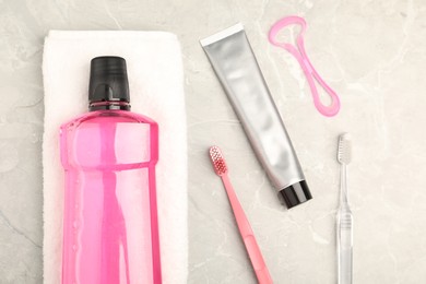 Photo of Mouthwash and other oral hygiene products on light marble table, flat lay