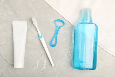 Photo of Mouthwash and other oral hygiene products on light marble table, flat lay