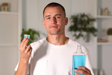 Photo of Man with bottle of mouthwash at home