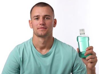 Photo of Man with bottle of mouthwash on white background