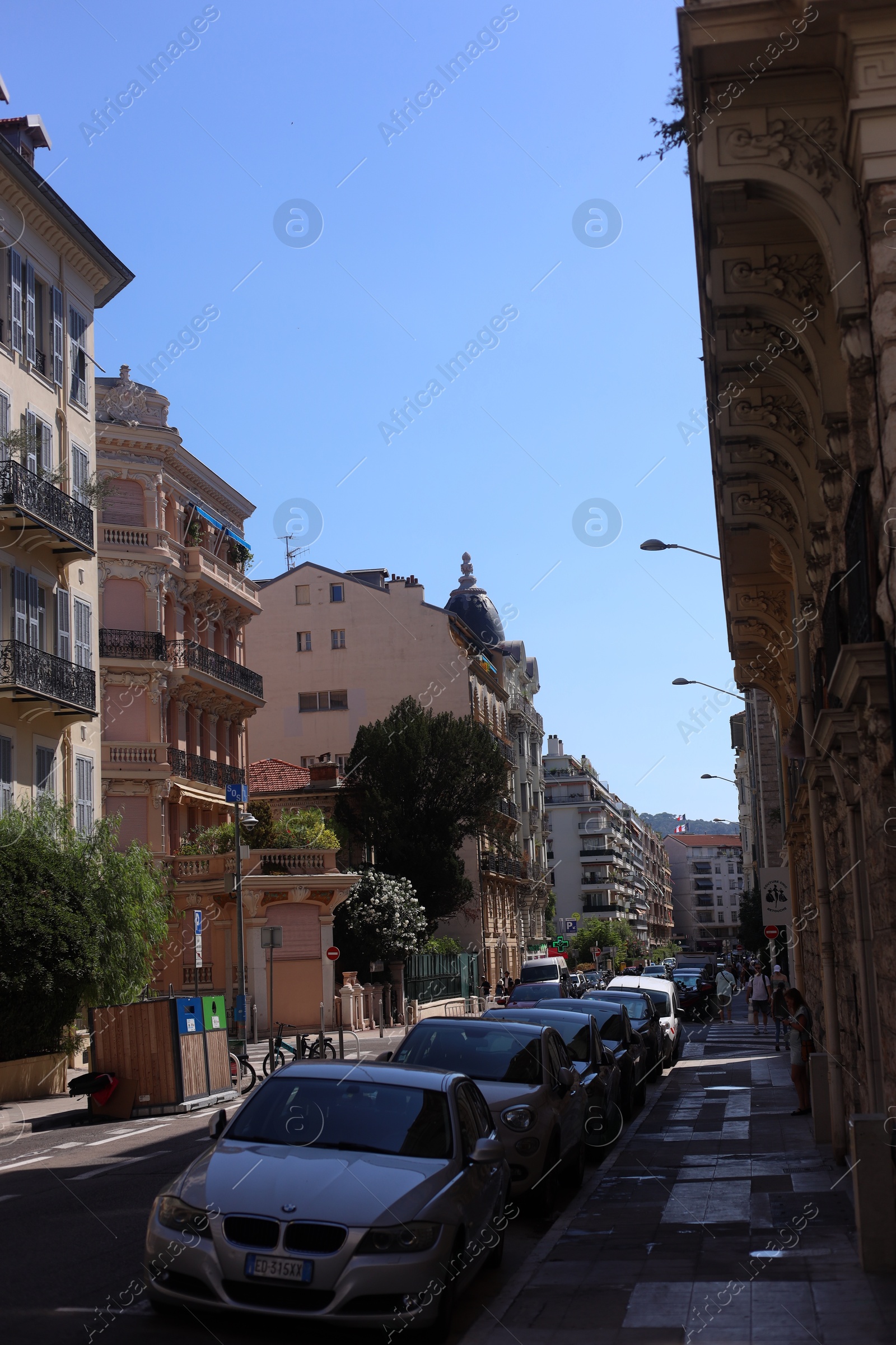 Photo of Nice, France - August 23, 2025: Beautiful buildings, trees and parked cars on city street