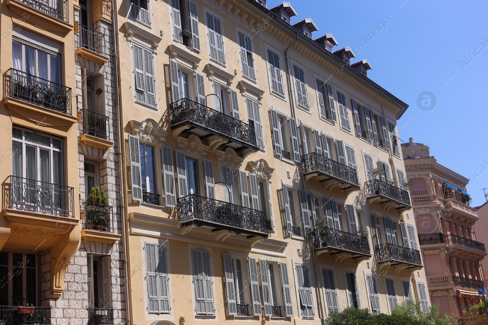 Photo of Nice, France - August 23, 2025: Beautiful building with windows and balconies against blue sky in city