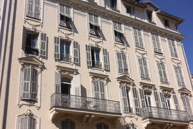 Photo of Nice, France - August 23, 2025: Beautiful building with windows and balconies against blue sky in city