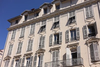 Photo of Nice, France - August 23, 2025: Beautiful building with windows and balconies against blue sky in city