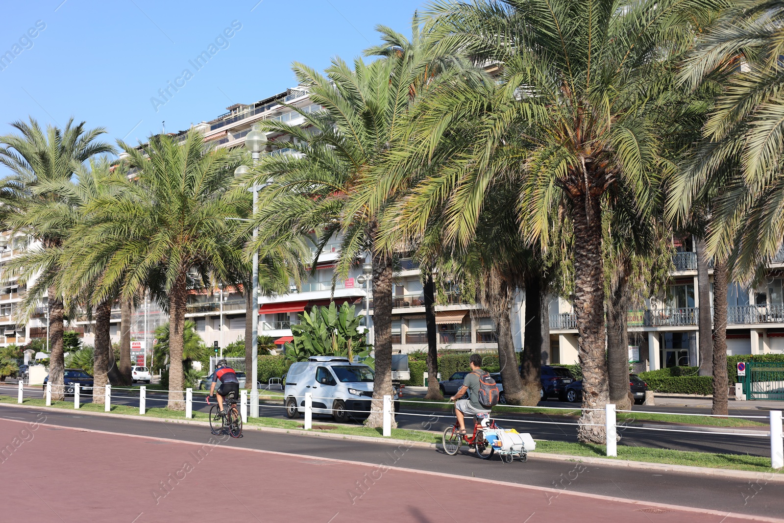 Photo of Nice, France - August 23, 2025: Beautiful palm trees and buildings on city street