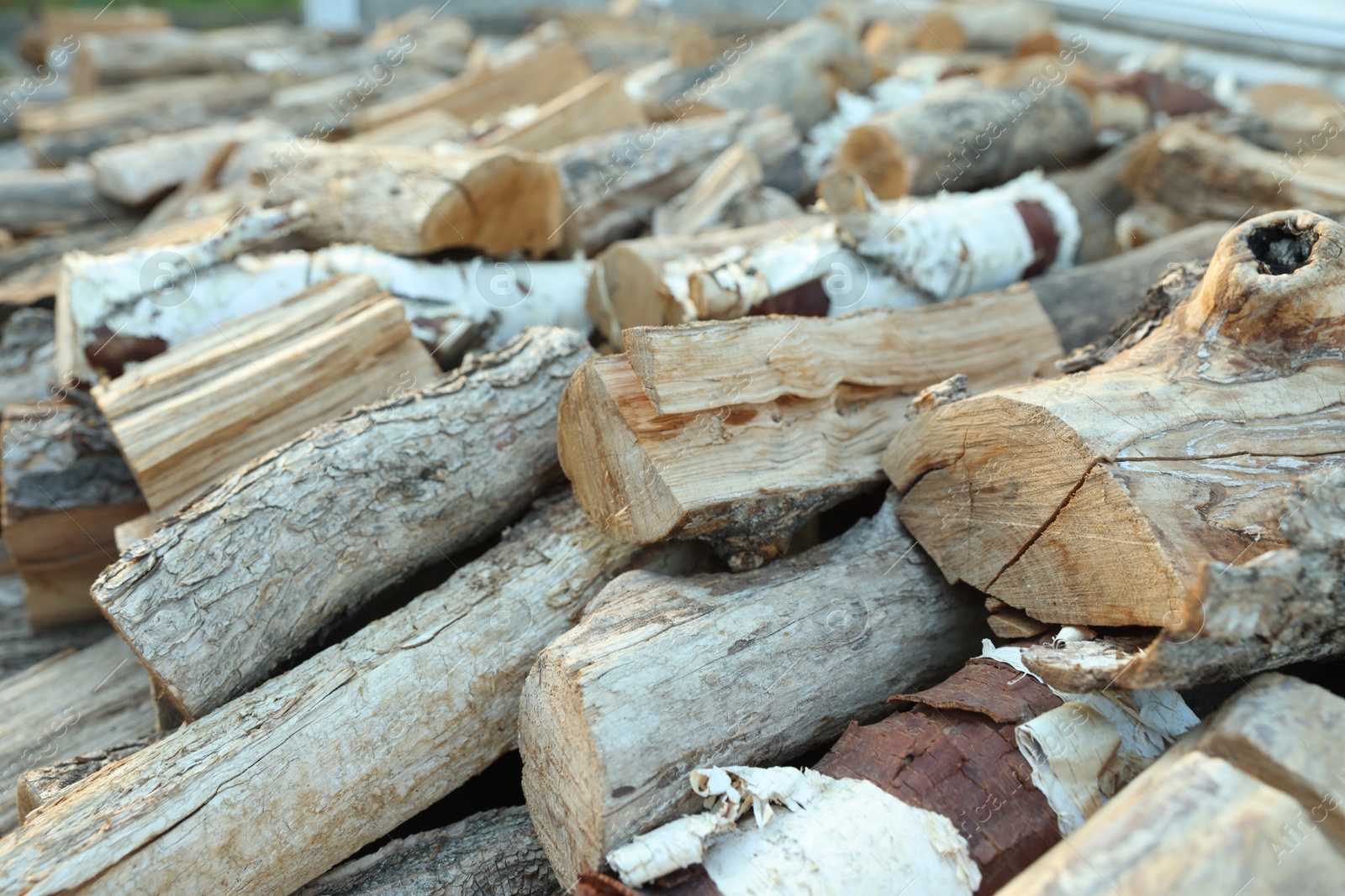 Photo of Pile of cut firewood outdoors, closeup view