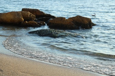 Photo of Beautiful wavy sea, stones and sandy beach