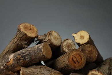 Photo of Pile of cut firewood on grey background, closeup