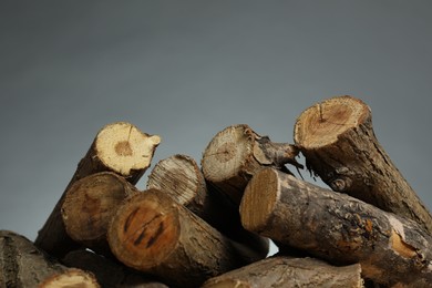 Photo of Pile of cut firewood on grey background, closeup