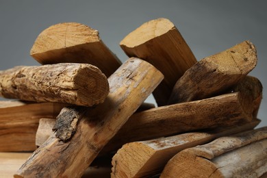 Photo of Pile of cut firewood on grey background, closeup