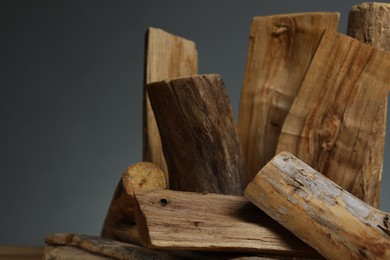 Photo of Pile of cut firewood on grey background, closeup. Space for text