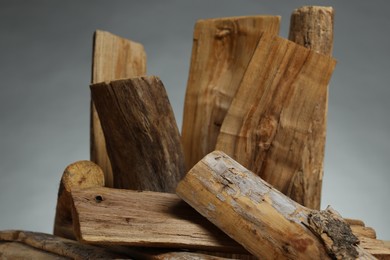 Photo of Pile of cut firewood on grey background, closeup