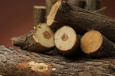 Photo of Pile of cut firewood on brown background, closeup