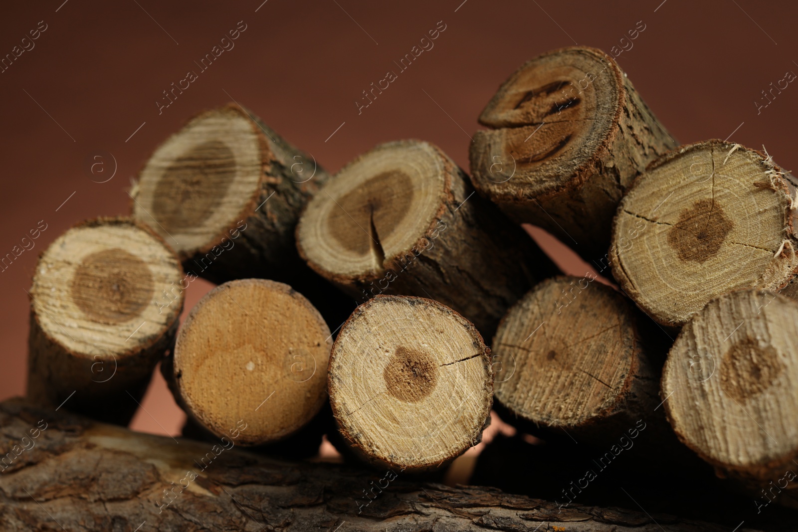 Photo of Pile of cut firewood on brown background, closeup