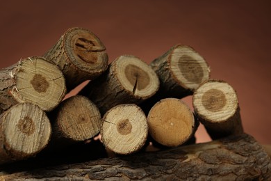 Photo of Pile of cut firewood on brown background, closeup