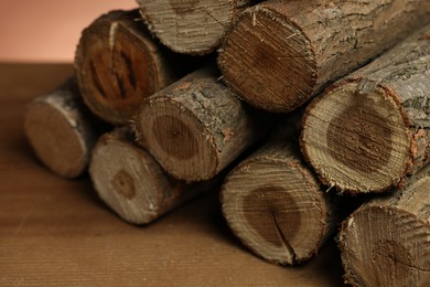 Photo of Pile of cut firewood on wooden table, closeup