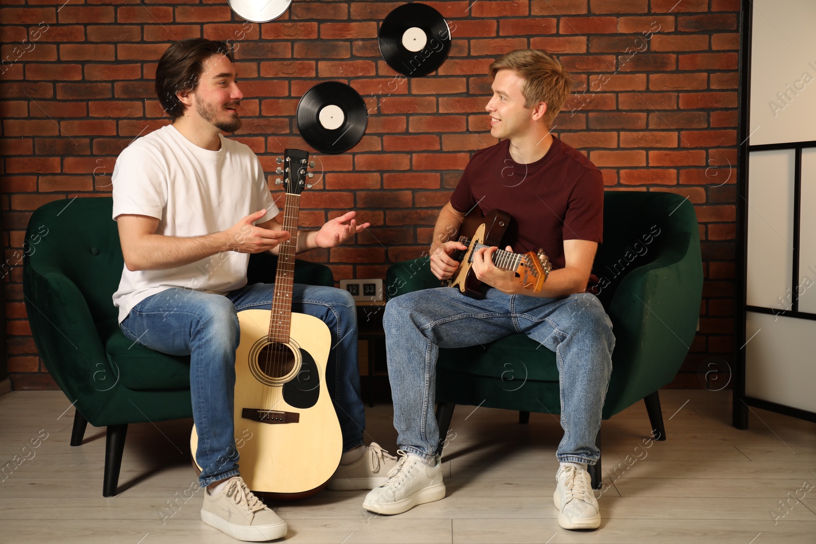 Photo of Tutor teaching man to play guitar indoors
