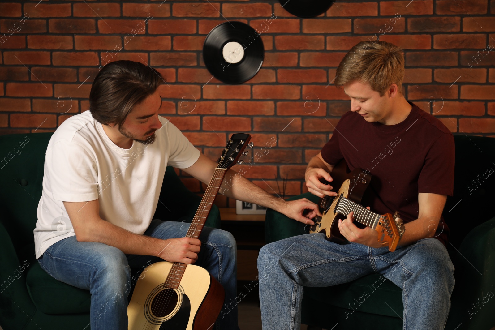 Photo of Tutor teaching man to play guitar indoors