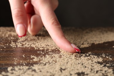 Photo of Woman swiping dust from wooden table, closeup