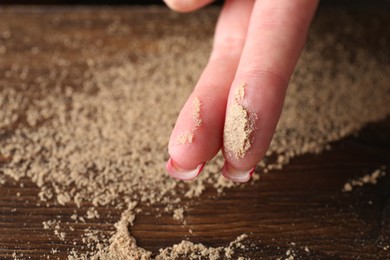 Photo of Woman showing dust from top of wooden table, closeup