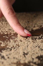 Photo of Woman swiping dust from wooden table, closeup