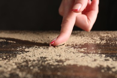 Photo of Woman swiping dust from wooden table, closeup