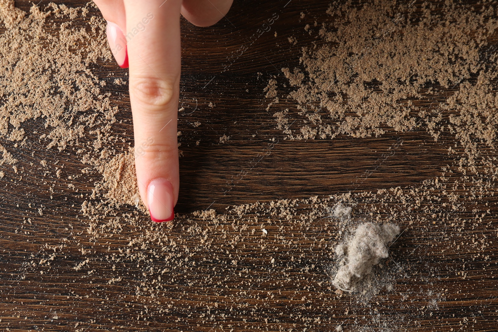 Photo of Woman swiping dust from wooden table, top view