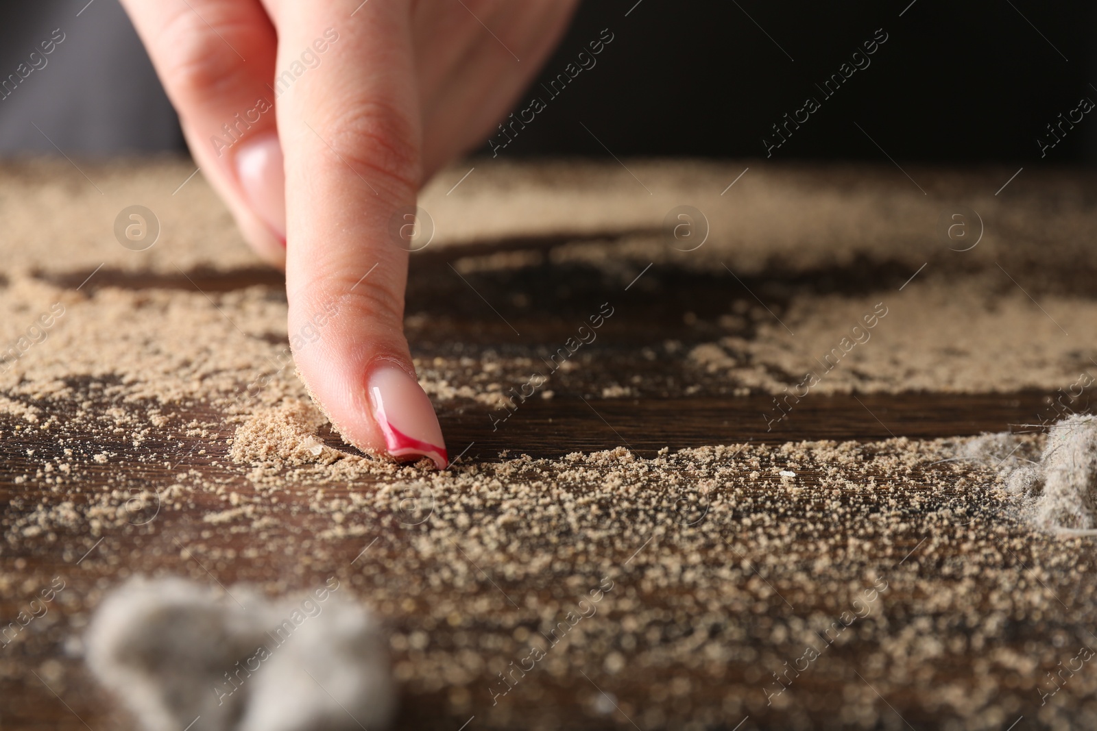 Photo of Woman swiping dust from wooden table, closeup