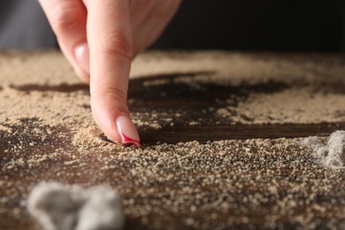 Photo of Woman swiping dust from wooden table, closeup