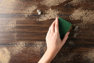 Photo of Woman wiping dust off wooden table, top view. Space for text