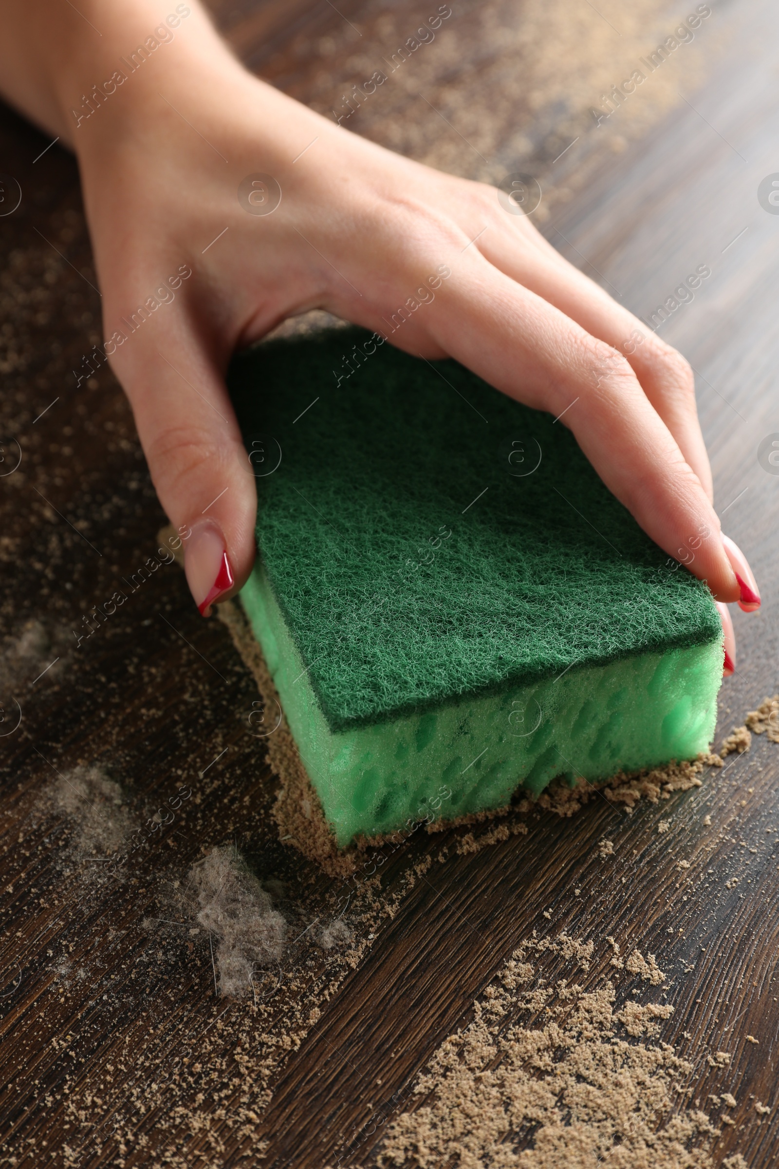 Photo of Woman wiping dust off wooden table, closeup