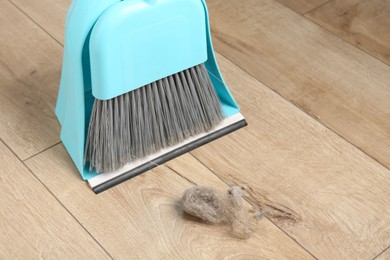 Photo of Dust bunny, dustpan and broom on floor indoors, above view