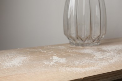 Photo of Wooden table covered with dust indoors, closeup