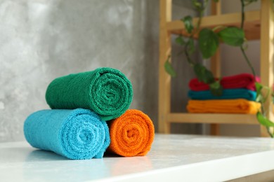 Photo of Fresh colorful terry towels on counter in bathroom, closeup. Space for text