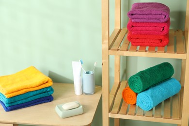 Photo of Fresh colorful terry towels and hygiene products in bathroom