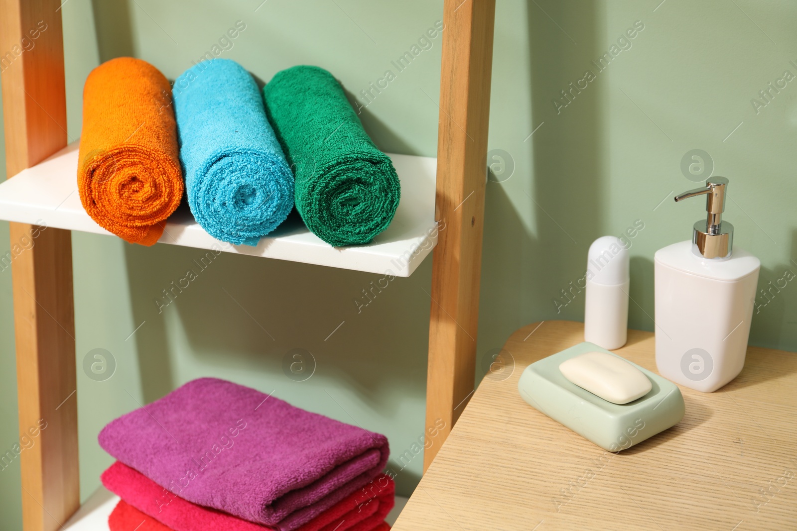 Photo of Fresh colorful terry towels and hygiene products in bathroom