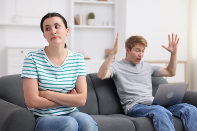 Photo of Woman feeling jealous of man's success at home, selective focus