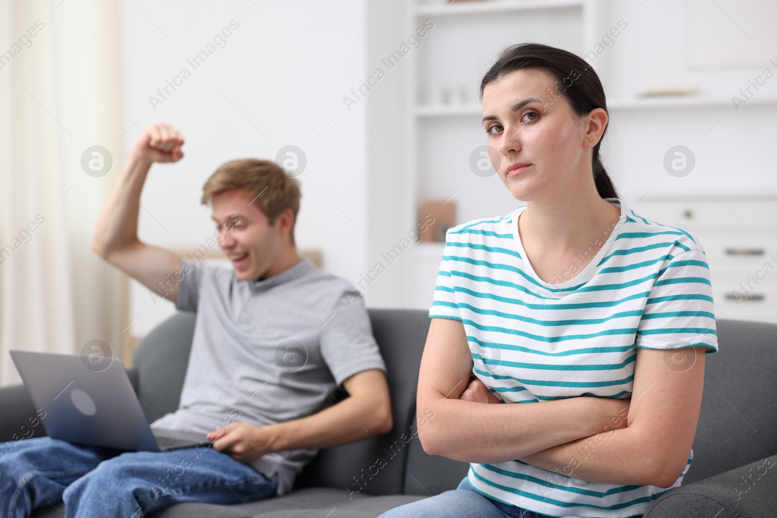 Photo of Woman feeling jealous of man's success at home, selective focus