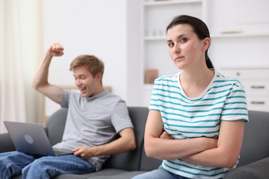 Photo of Woman feeling jealous of man's success at home, selective focus