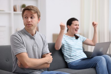 Photo of Man feeling jealous of woman's success at home, selective focus