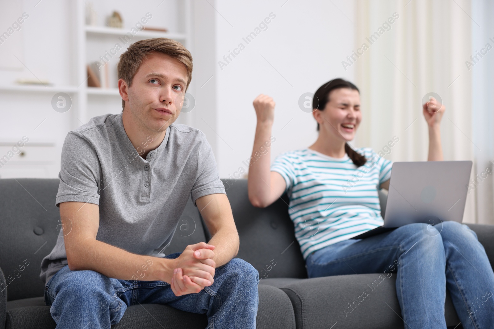 Photo of Man feeling jealous of woman's success at home, selective focus