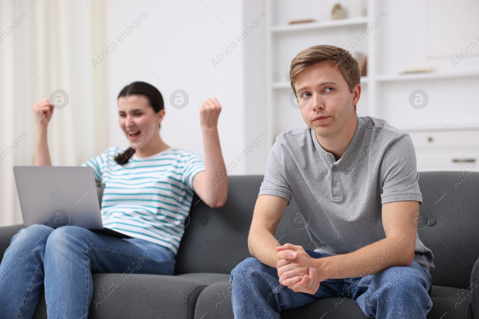 Photo of Man feeling jealous of woman's success at home, selective focus